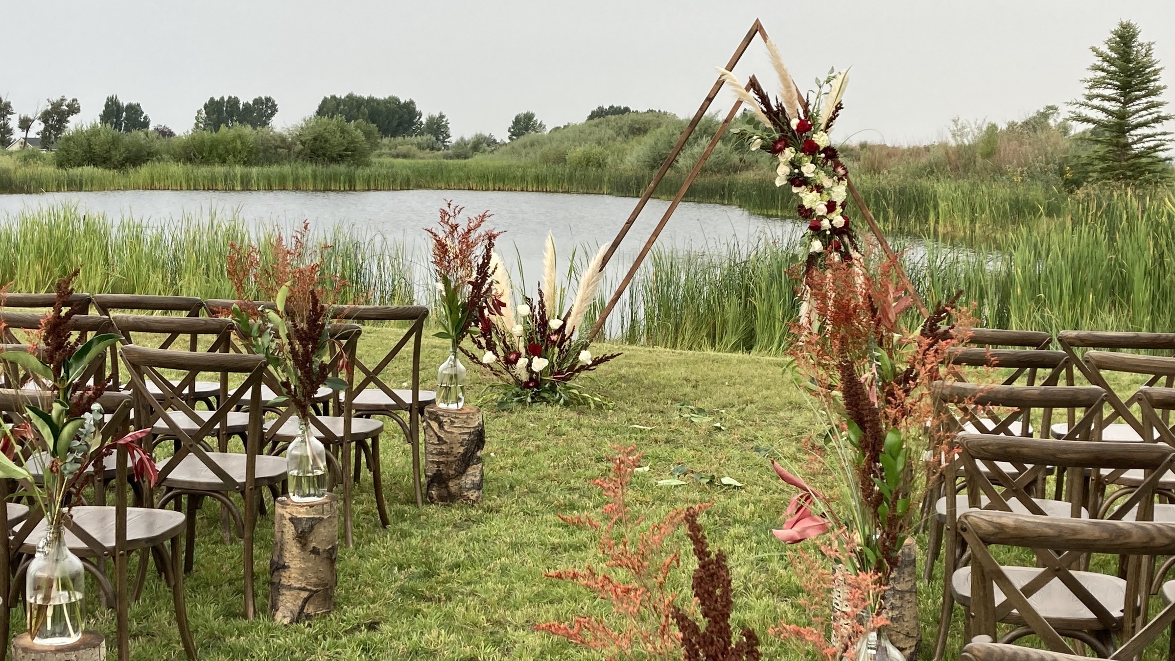 Outdoor wedding ceremony by the pond at Three Peaks Lodge